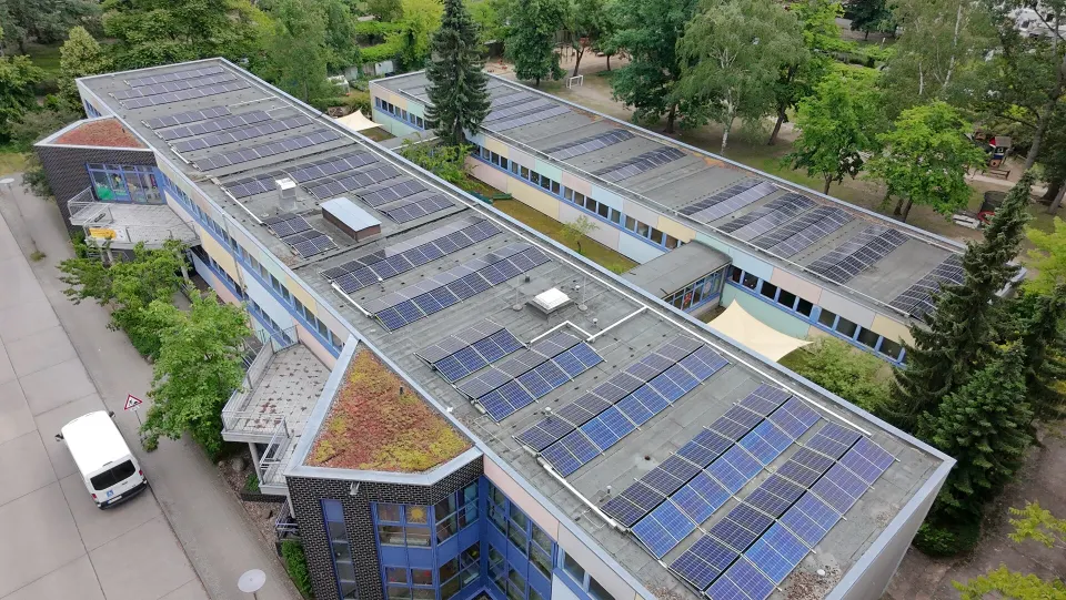 Luftaufnahme der Photovoltaikmodule auf zwei Dächern einer Berliner Kita
